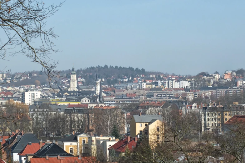 a town with several tall buildings and a hill in the background