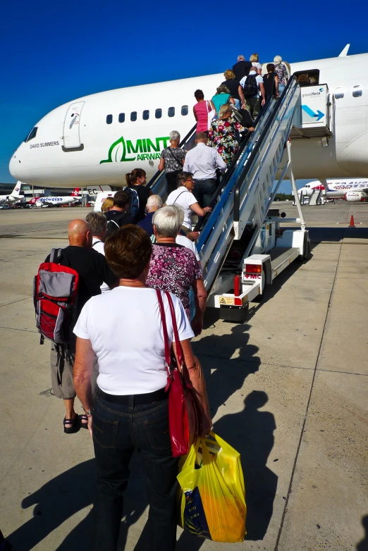 some people who are standing on a stairs going up to a plane