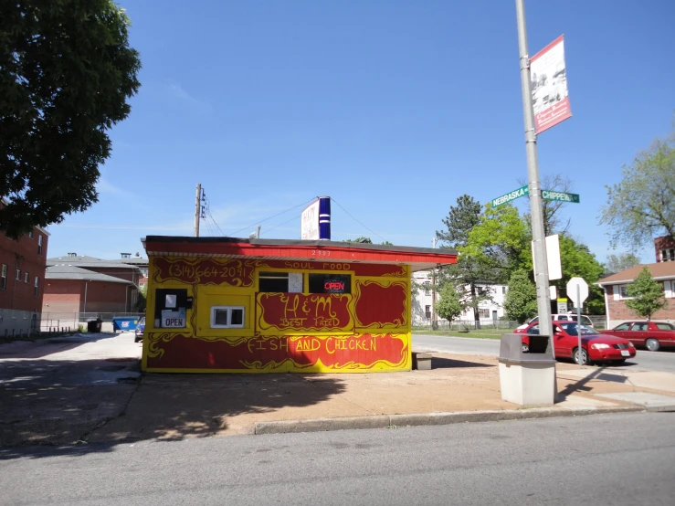 a small yellow and red building near the street