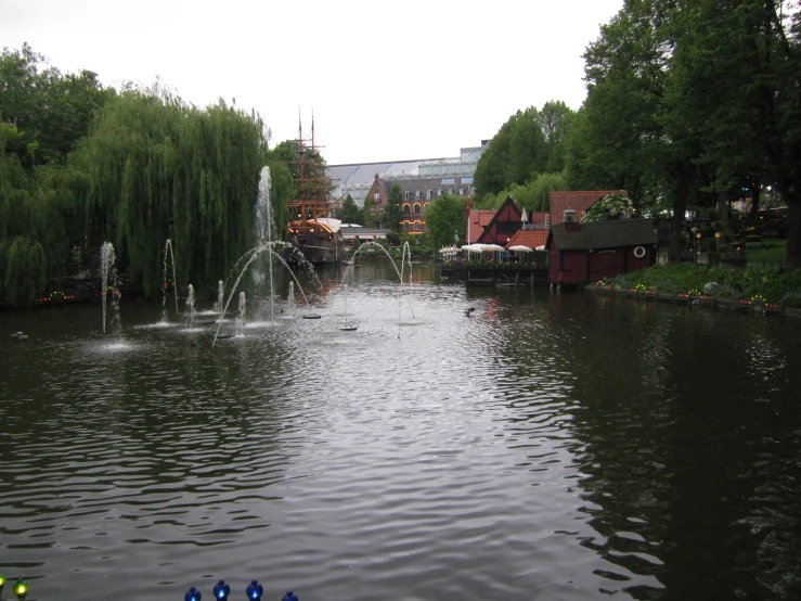 there is a large pond with a clock tower in the back