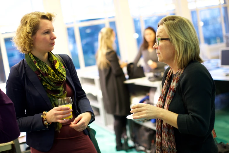 two women talk to each other at a party