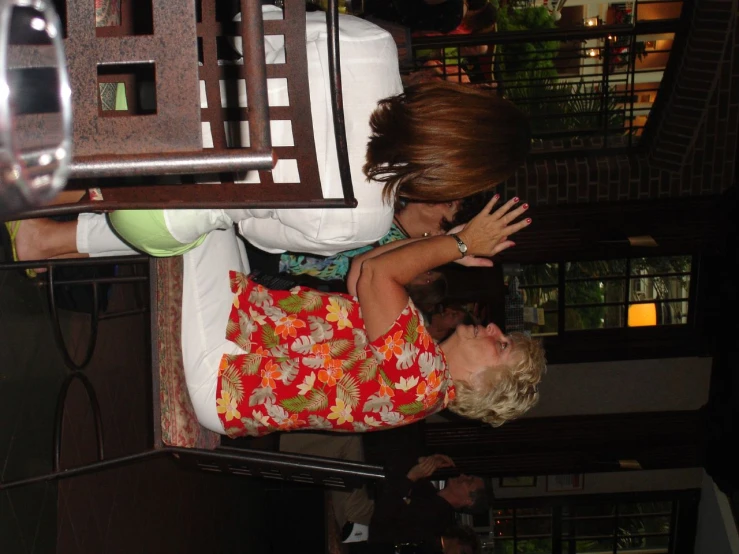 a woman is touching another woman's head while they have their hands and heads in the air