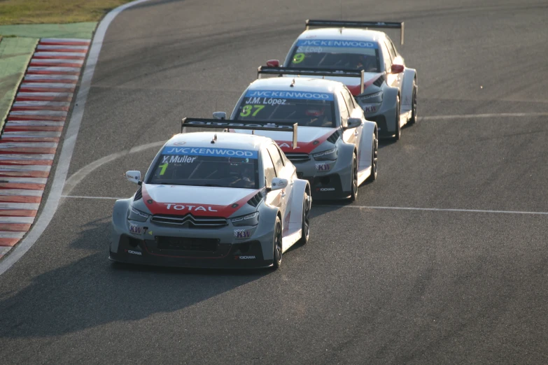 four race cars driving on a race track