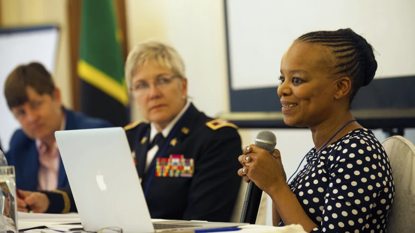 two women in uniforms sitting at a table talking