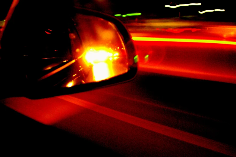 a car's rear view mirror with a red light