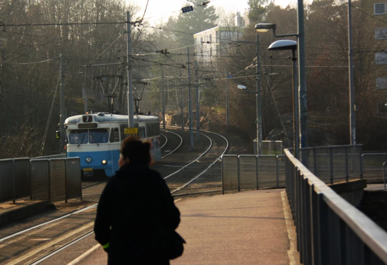 a blue and white passenger train traveling down tracks