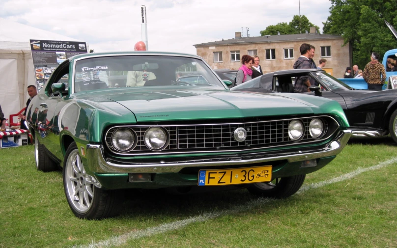 a vintage green car at a car show