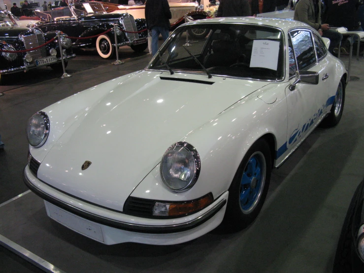 a white porsche type 911 sports car on display at a car show