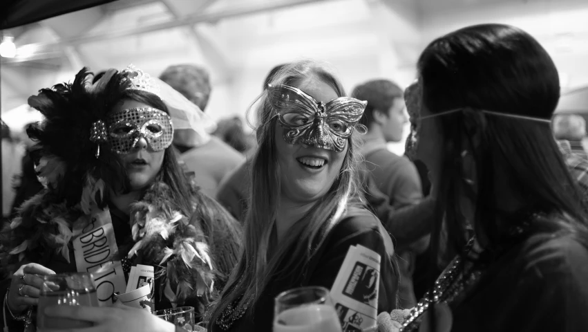 three women standing together smiling and wearing masks