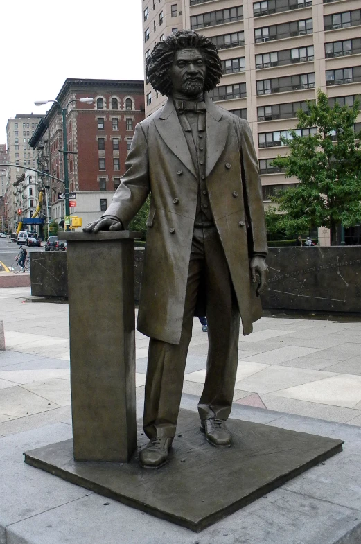 a large statue of a man holding a book and hat