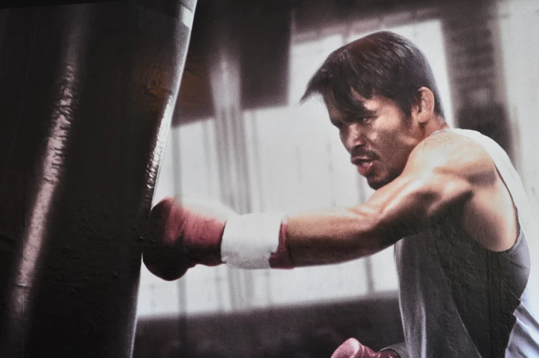 man wearing boxing gloves leaning on the punching bag