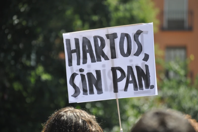 a white sign with black writing on it in a demonstration