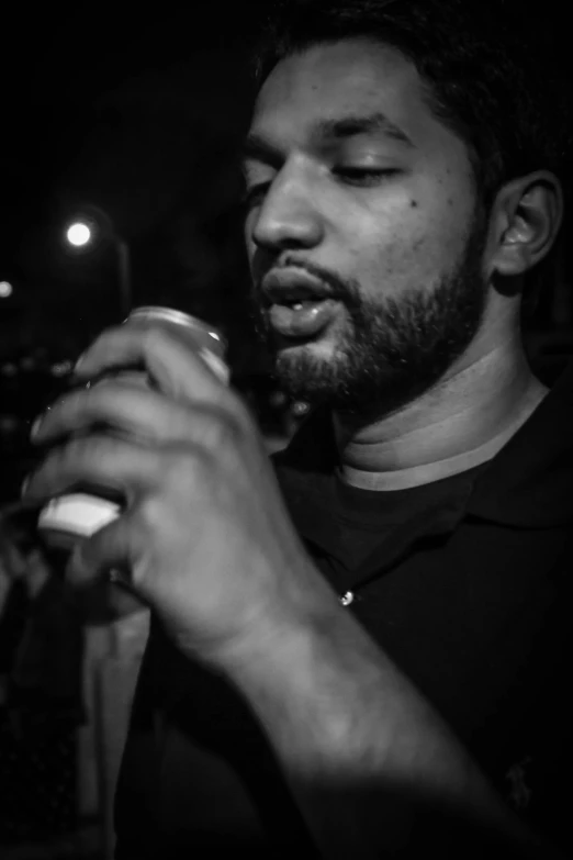 a man looks at his cell phone while wearing a black polo shirt