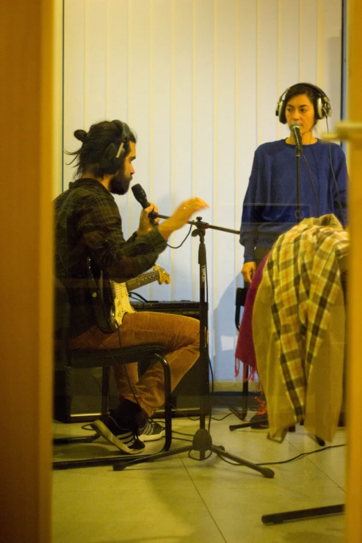 a woman sitting next to a microphone in front of another person