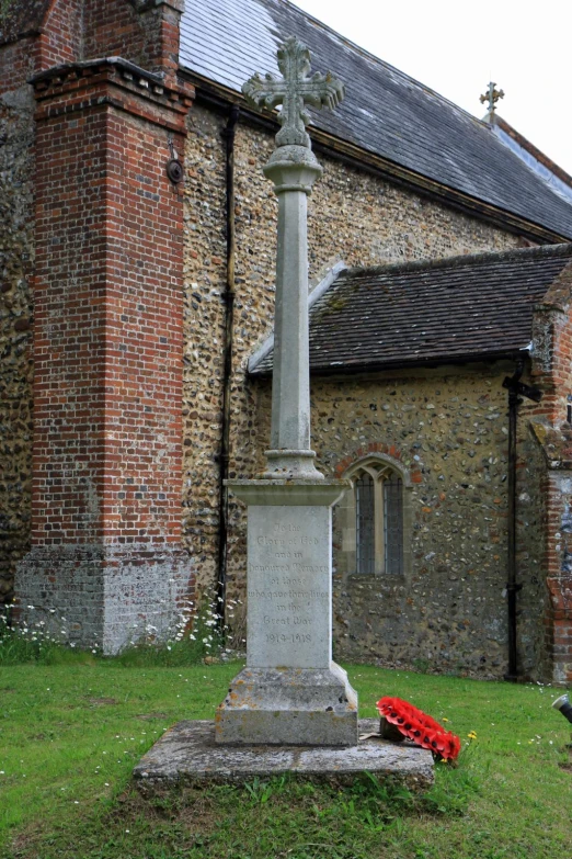 the grave with a cross stands in front of a building