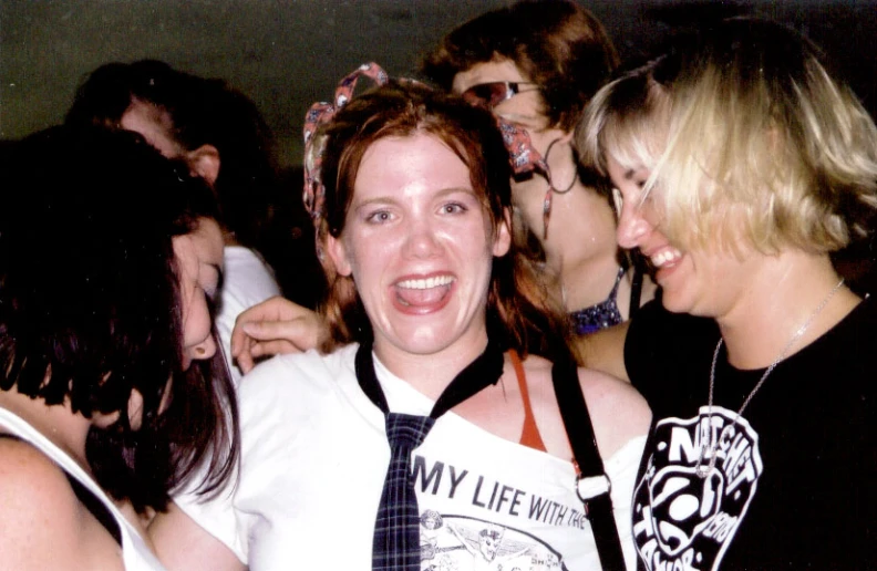 woman standing between others in party attire