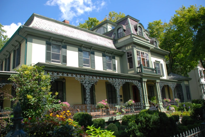 an old victorian home with a garden in front of it