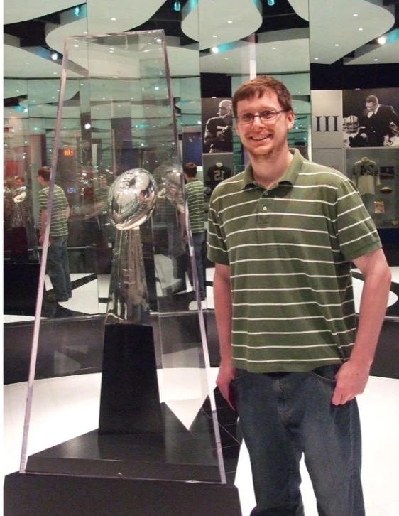 a man posing with a large globe on display