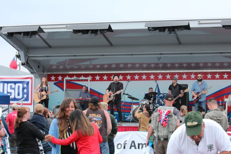 several people are watching as bandleader performs on a stage