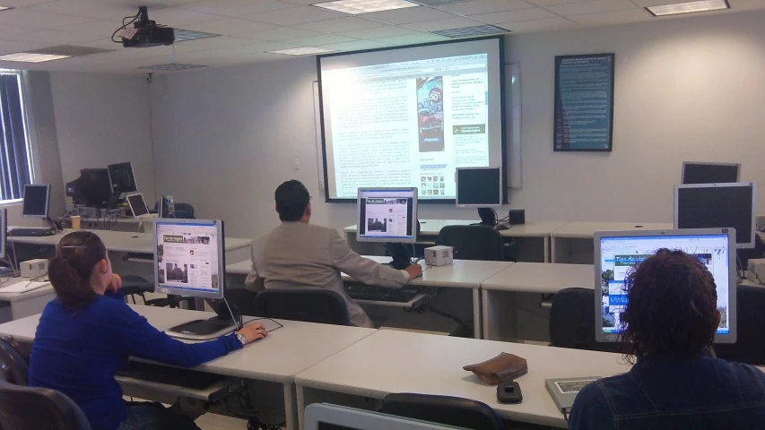 two men are in front of some computers