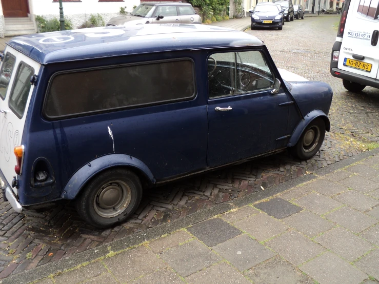 an old car parked on the side of a street