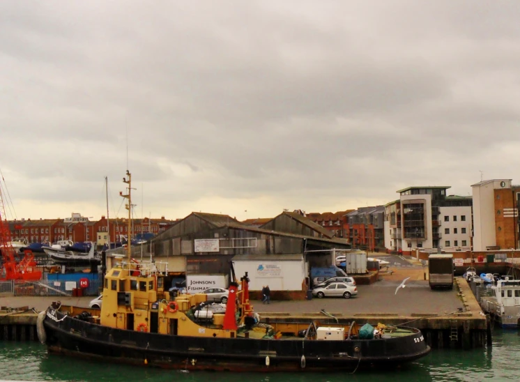 a boat in the harbor in front of some other boats