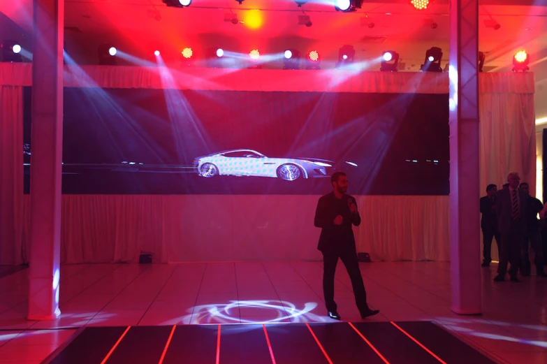 a person standing in front of a car on display