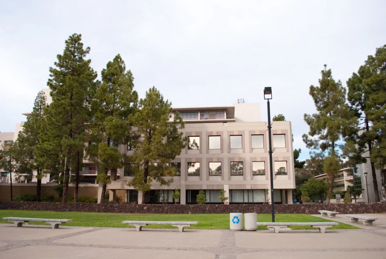 a building surrounded by park benches on a clear day