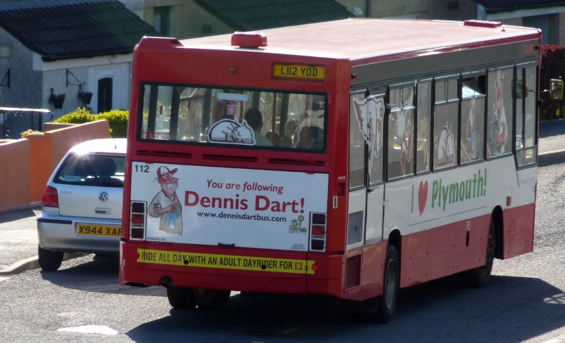 there is a small red and white bus in traffic