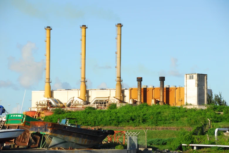 a factory with four towers and a large boat