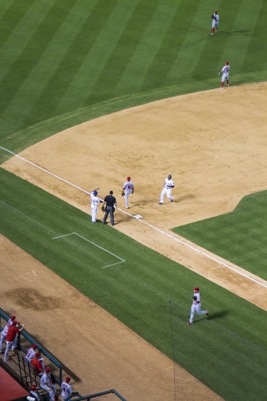 two baseball players running on the field with the umpire in the background