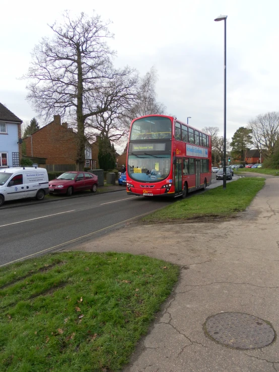 double decker bus on street near grass and buildings