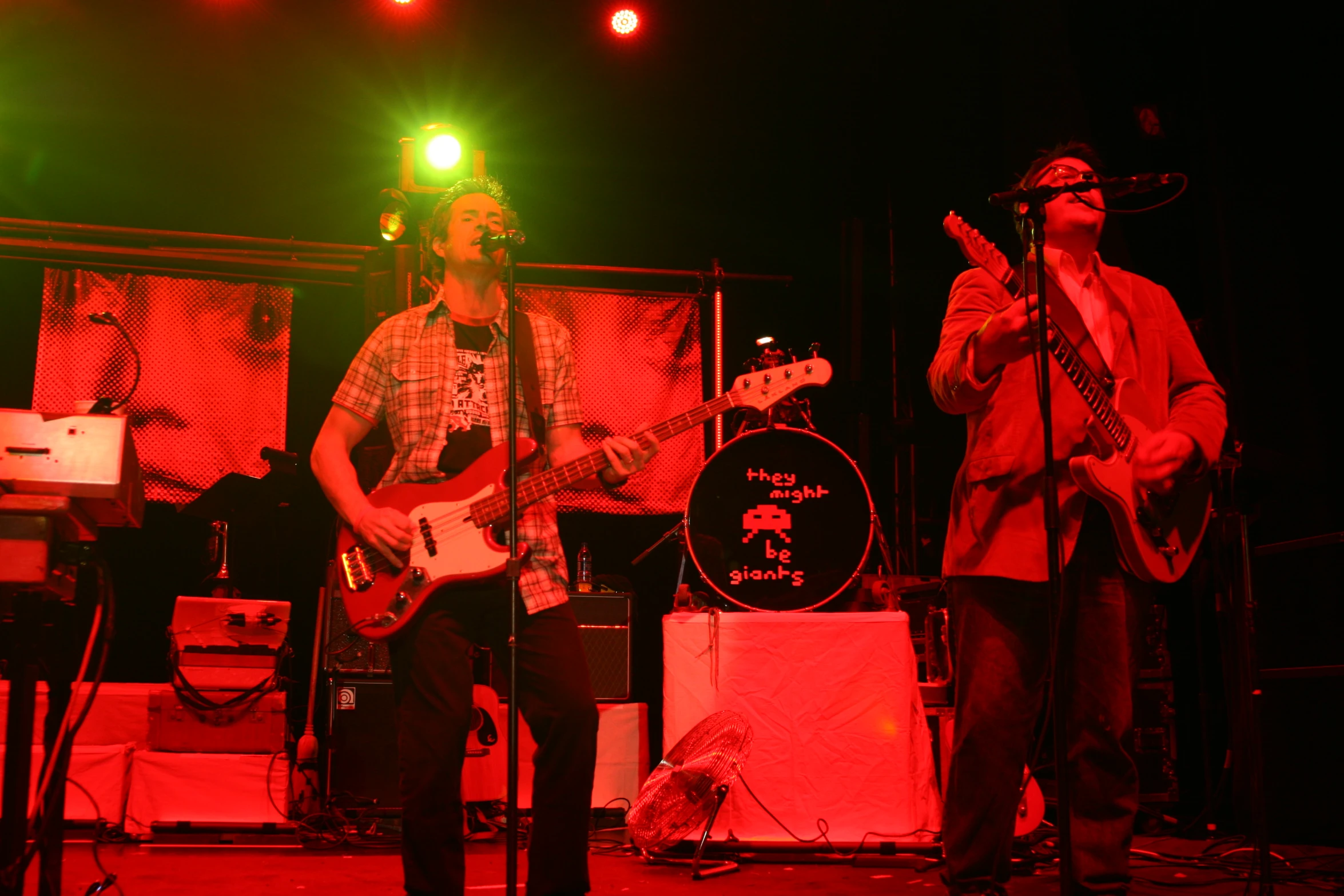 two men playing instruments with a green light in the background