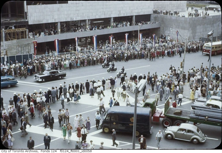 this vintage po shows a crowd gathered in a city square