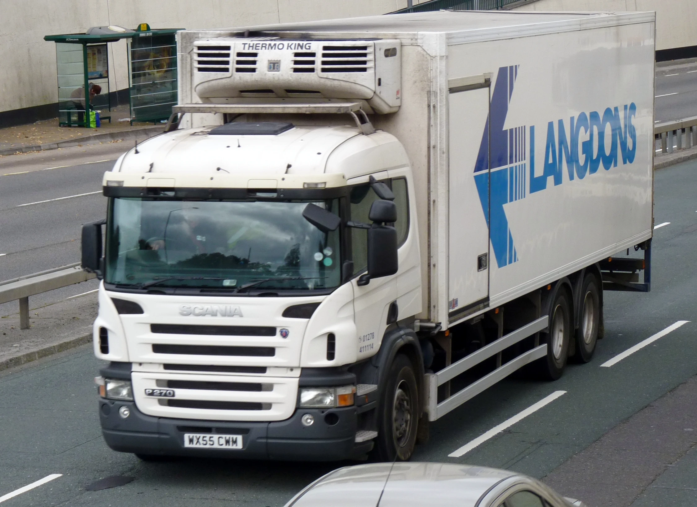 a truck driving on the road near some buildings