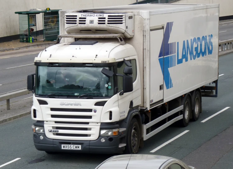 a truck driving on the road near some buildings