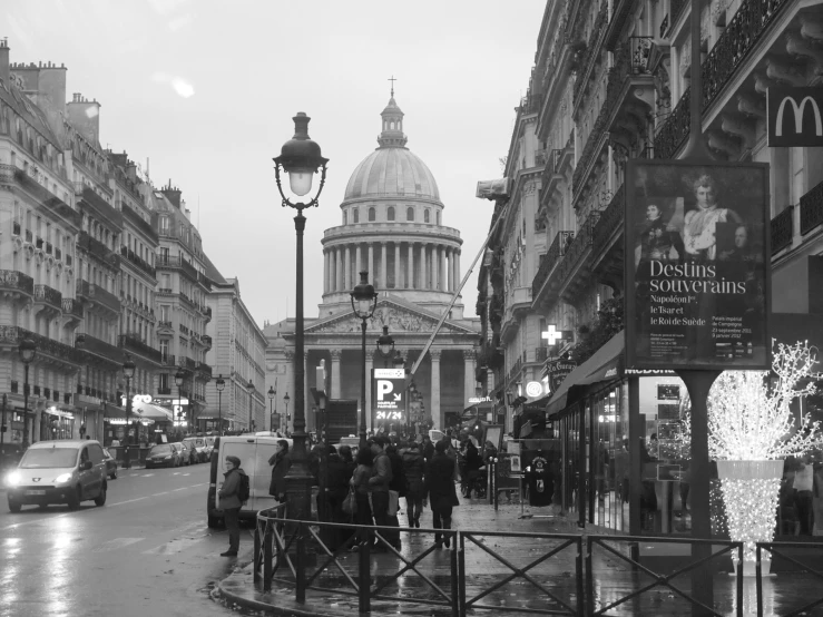 some people are walking in the street by some buildings