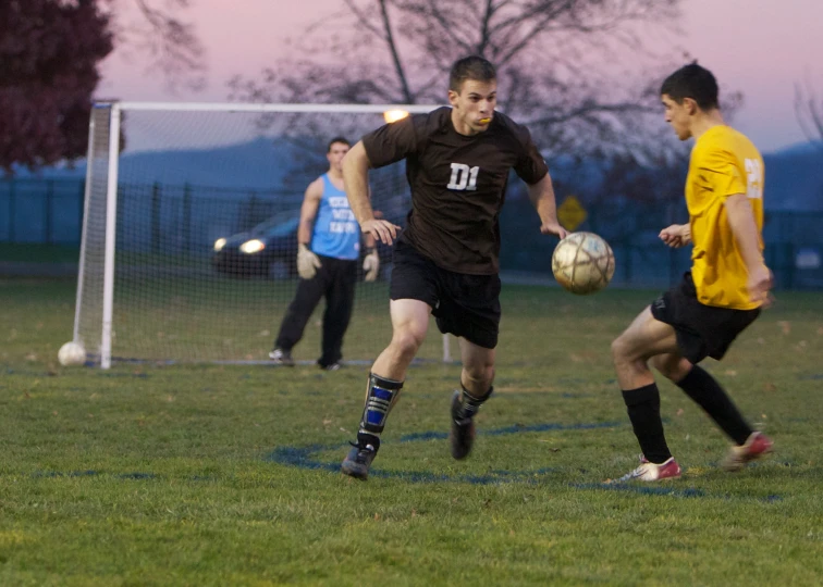 boys are playing soccer in a grassy field