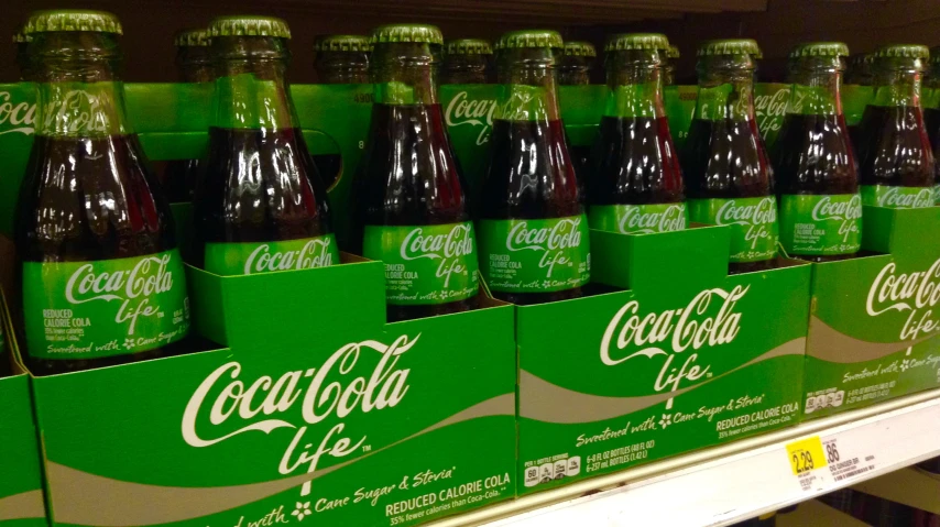 a shelf of different types of coca cola bottles