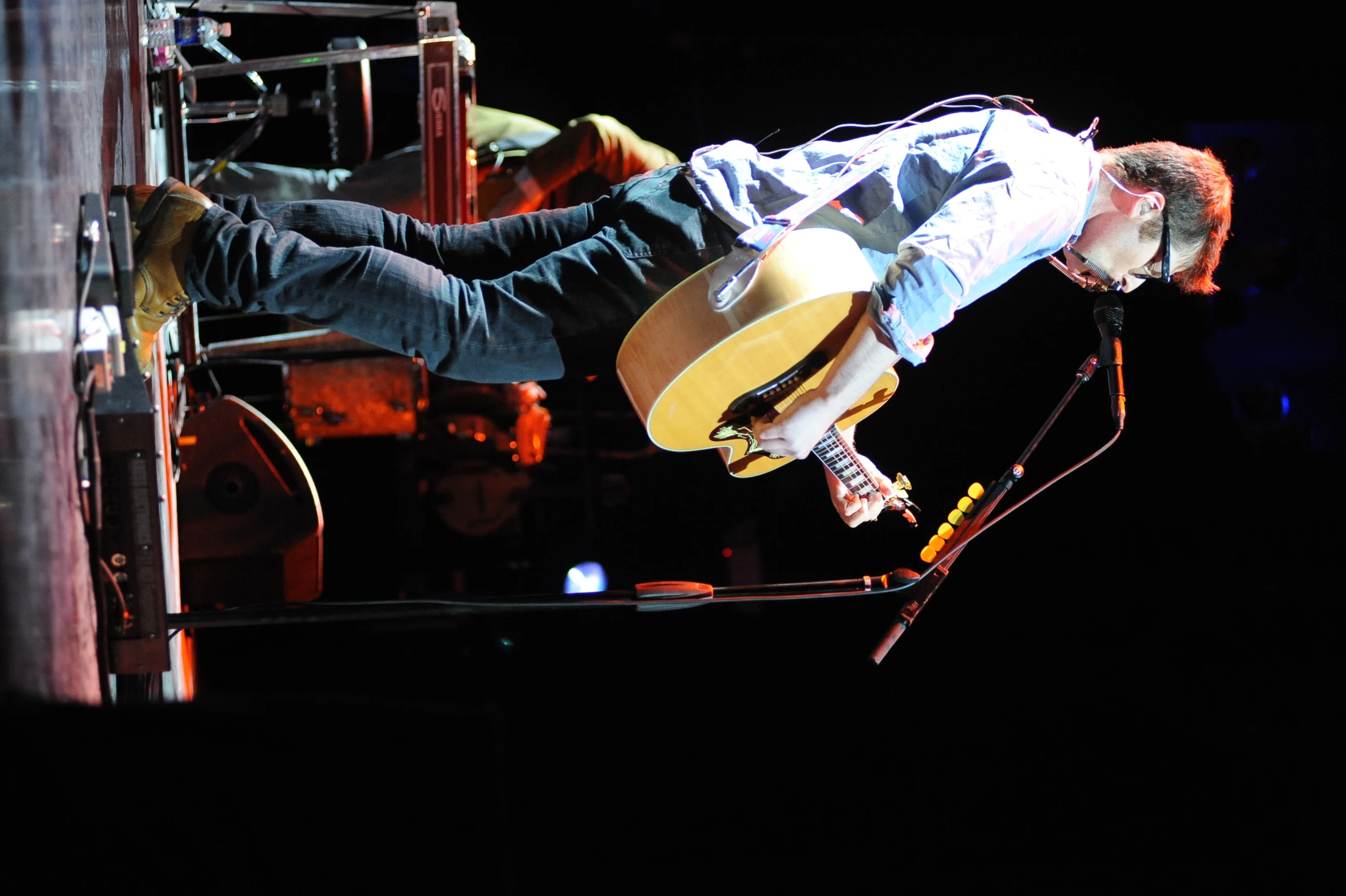 a man is holding a guitar and singing