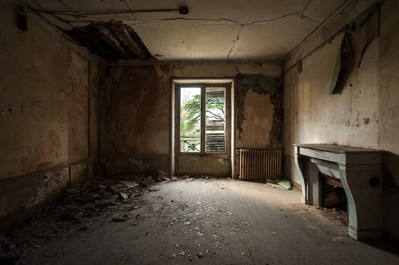 an abandoned room with a fireplace and debris all over it