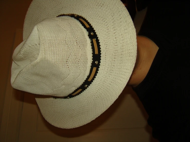 a white hat with some brown leather on it