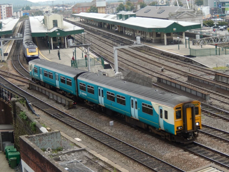 there are two blue and yellow trains next to each other