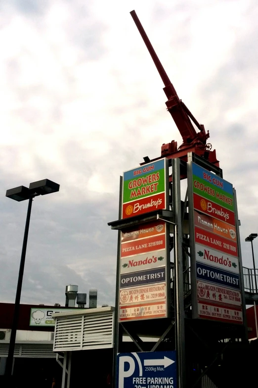 a tall crane sitting on top of a pole next to parking signs
