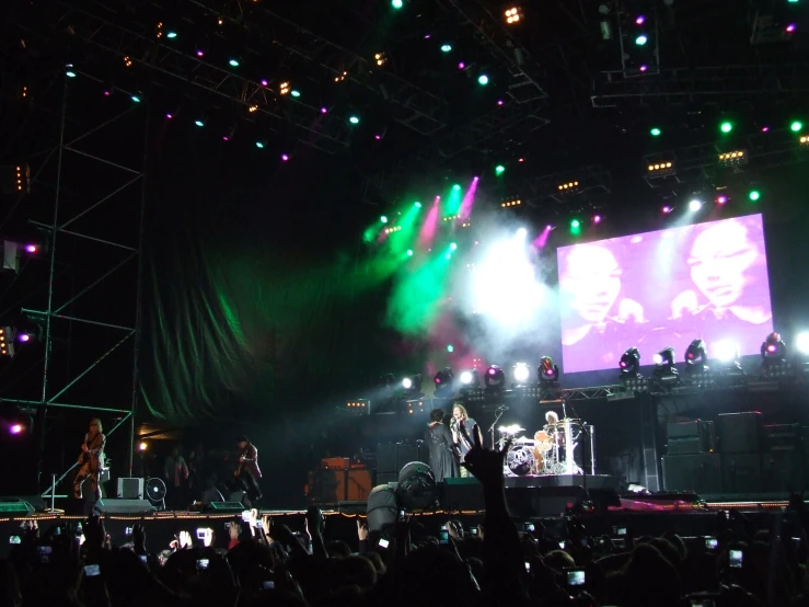 a group of people on stage watching lights shine through