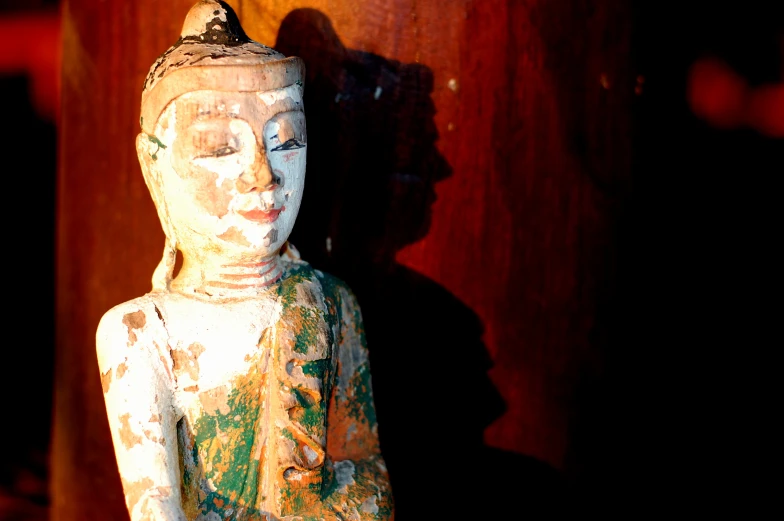 an old statue of buddha in white on a table