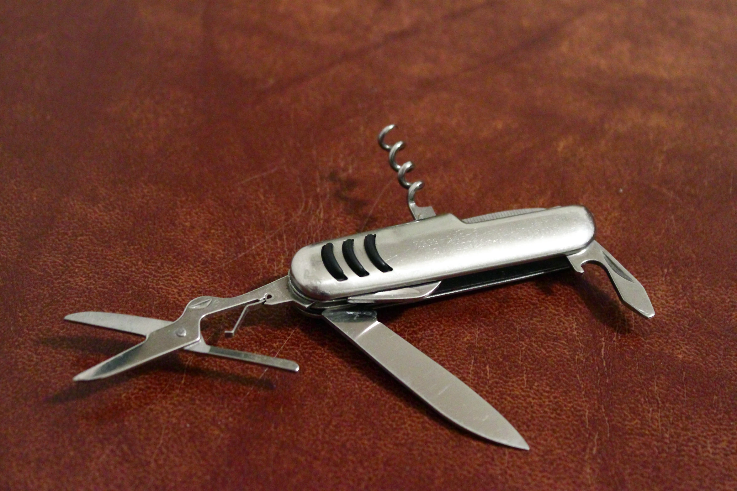 a stainless steel swiss army knife with black trim