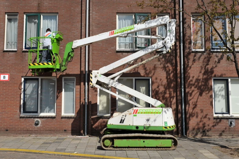 a man is working with a green and white device