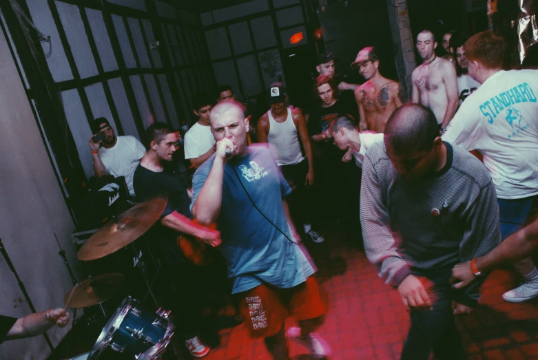 a group of men in a room with a drum set