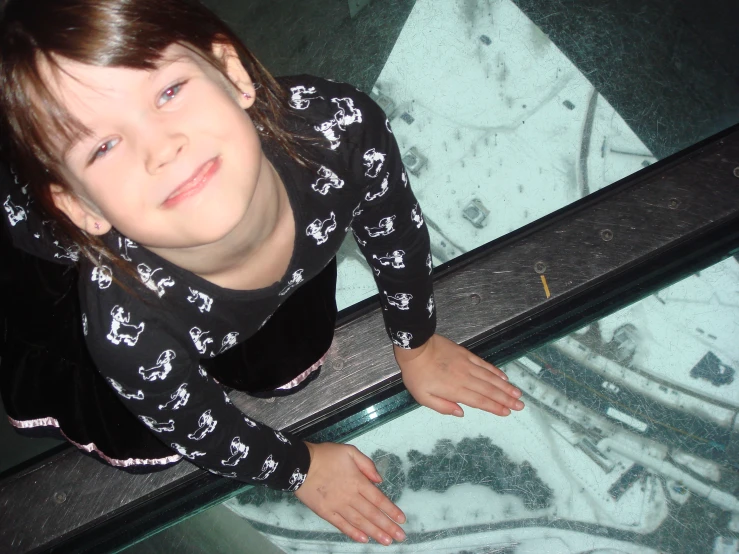 a  wearing pajamas poses with her hands on a glass floor